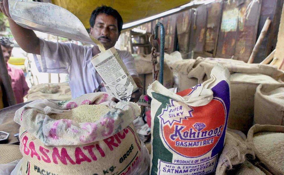 A rice vendor fills a small paper packet with Basmati rice in Calcutta