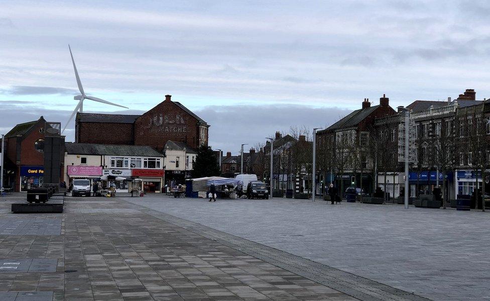 An empty Blyth market place with the wind turbine in the background