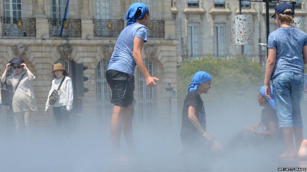 Young people playing in a fountain