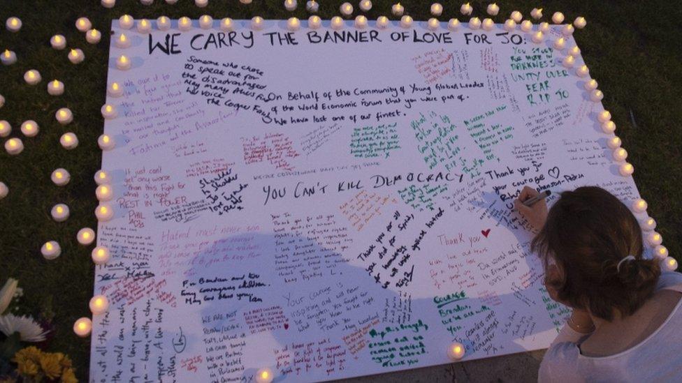 A woman writing a tribute message to Jo Cox in Parliament Square