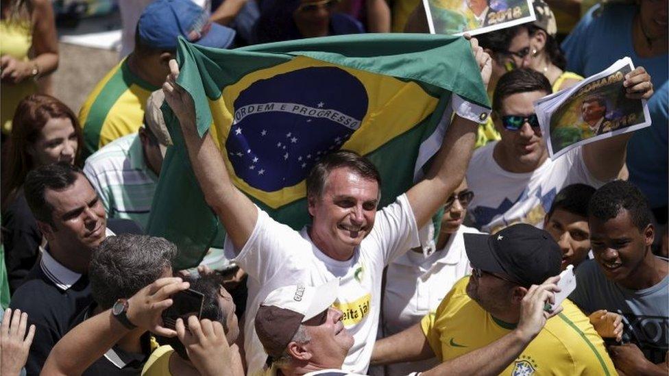 Congressman Jair Bolsonaro holds a Brazilian flag during a protest against Brazil's President Dilma Rousseff, part of nationwide protests calling for her impeachment, in Brasilia, Brazil, March 13, 2016