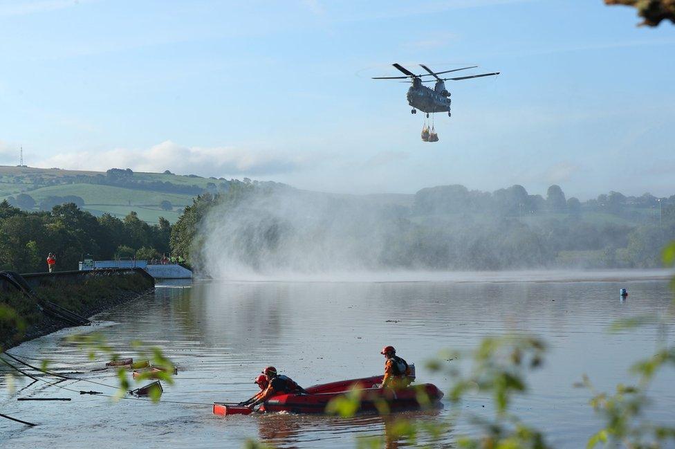 Helicopter flies in over reservoir