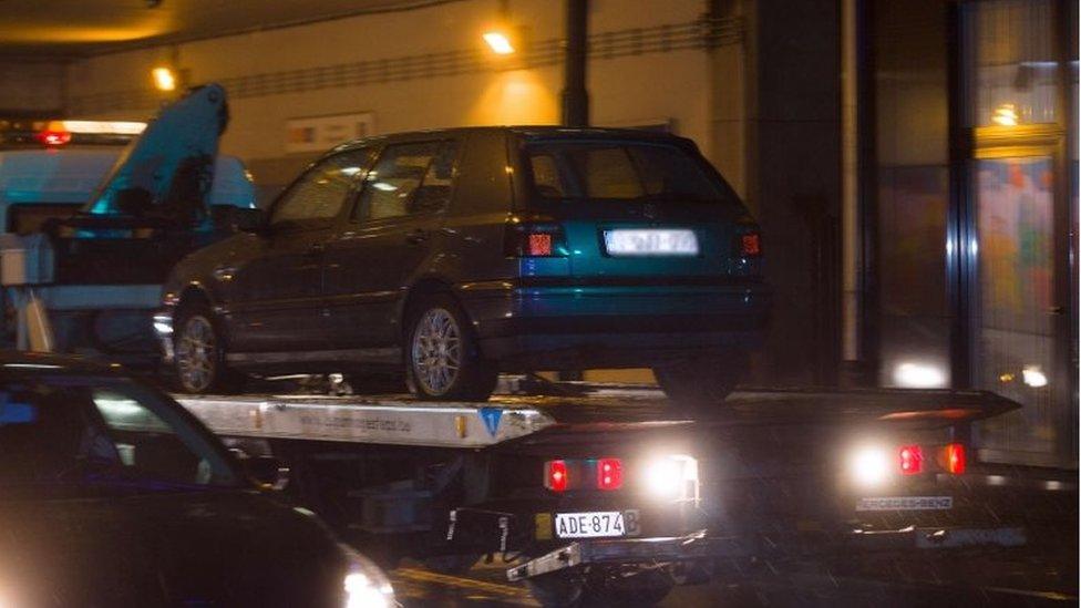 A car is towed during a police raid in Brussels's Molenbeek district in connection with the attacks in Paris (14 November 2015)