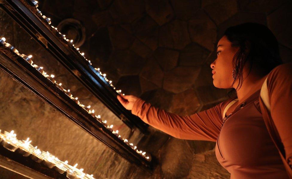 A worshiper lights a candle at St. Joseph"s Cathedral Catholic Church in Abu Dhabi, United Arab Emirates, 24 December 2019