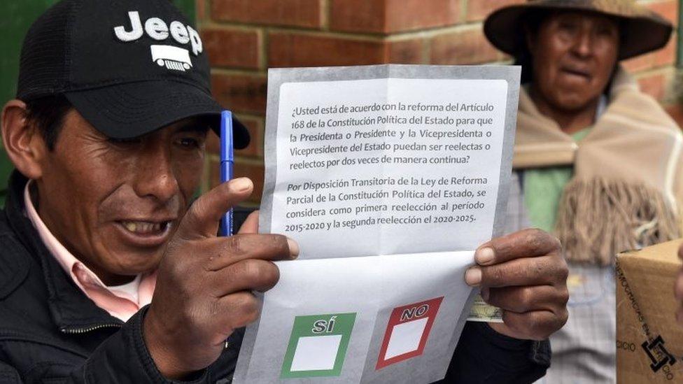 An election judge shows the ballot to a voter on 21 February 21, 2016 in Huarina, 75 km from La Paz