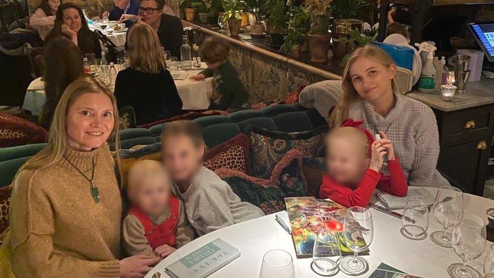 Tetyana and Mariia with their children at a restaurant