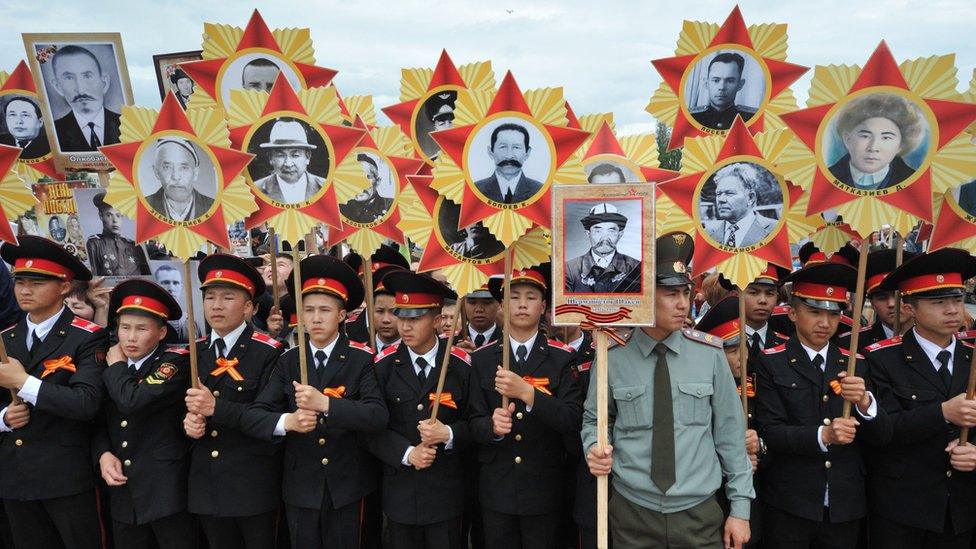 Kyrgyz military cadets hold portraits of World War Two soldiers as they take part in the Immortal Regiment march in Bishkek on May 9, 2016