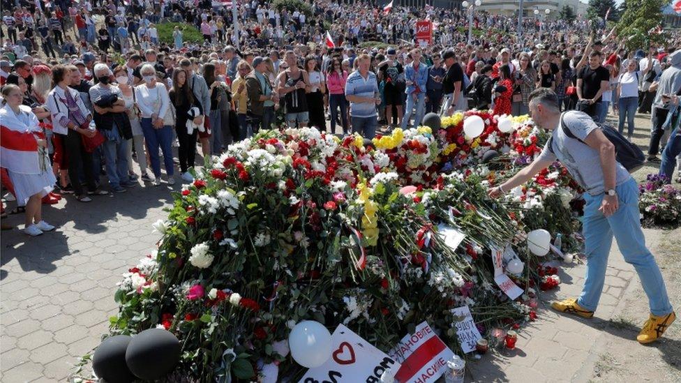 People place flowers at a makeshift memorial on Saturday