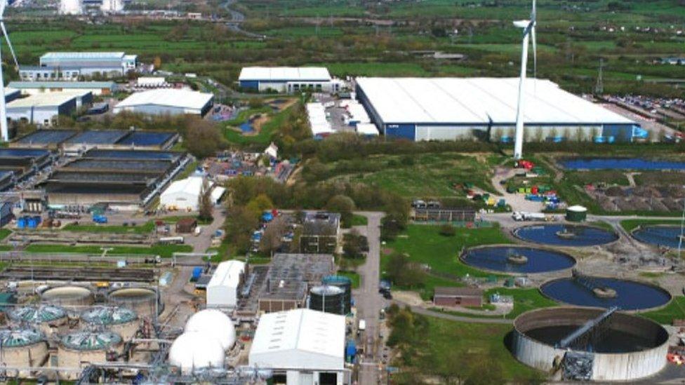 A large industrial site with several large warehouses and pumps on it