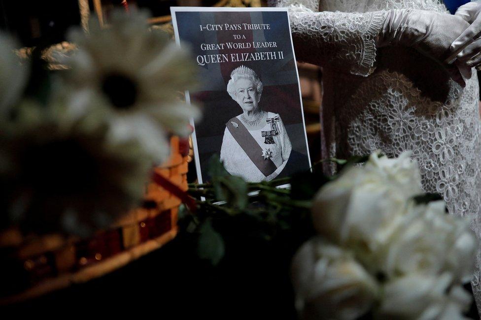 A note and a bouquet of flowers are pictured next to a wax model of Queen Elizabeth II at a wax museum in Shah Alam, Malaysia September 9, 2022.