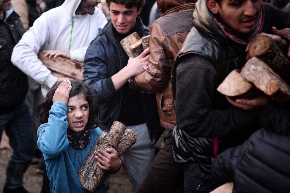 A child holds firewood