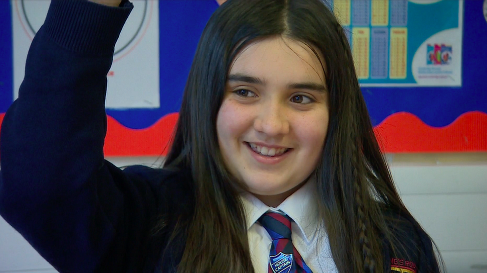 A student at Kings Road Primary with her hand up