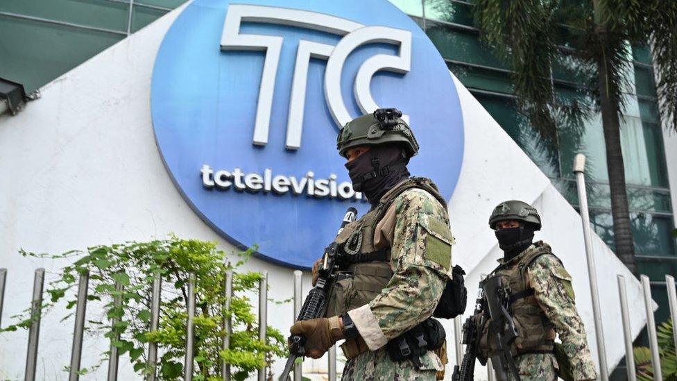 Soldiers patrol outside the broadcast channel targeted by gangs earlier this week