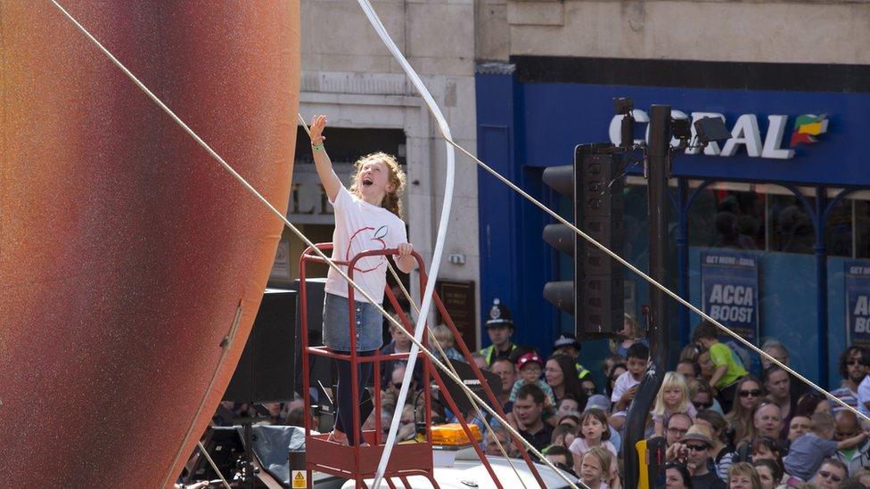 A young girl touching the giant peach