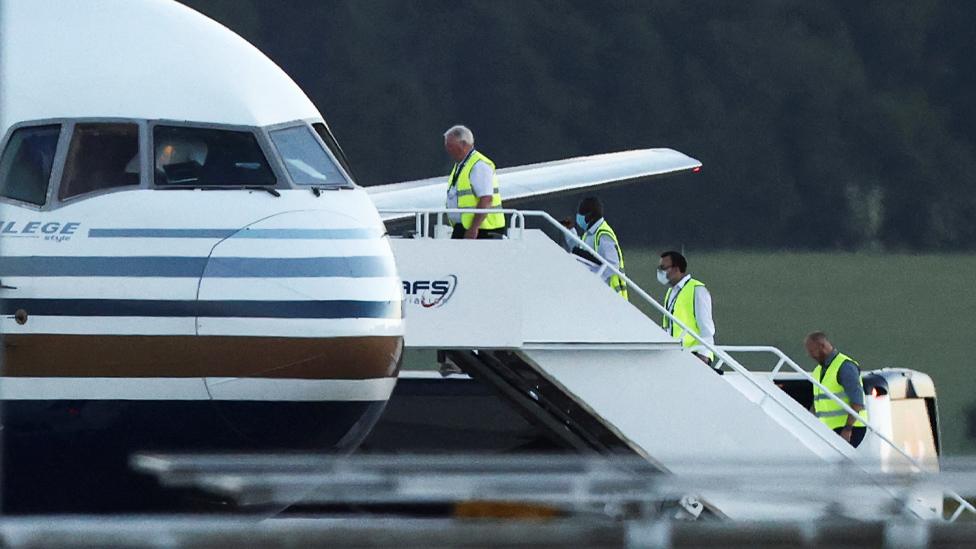 Members of staff board a plane reported by British media to be first to transport migrants to Rwanda, at MOD Boscombe Down in June 2022