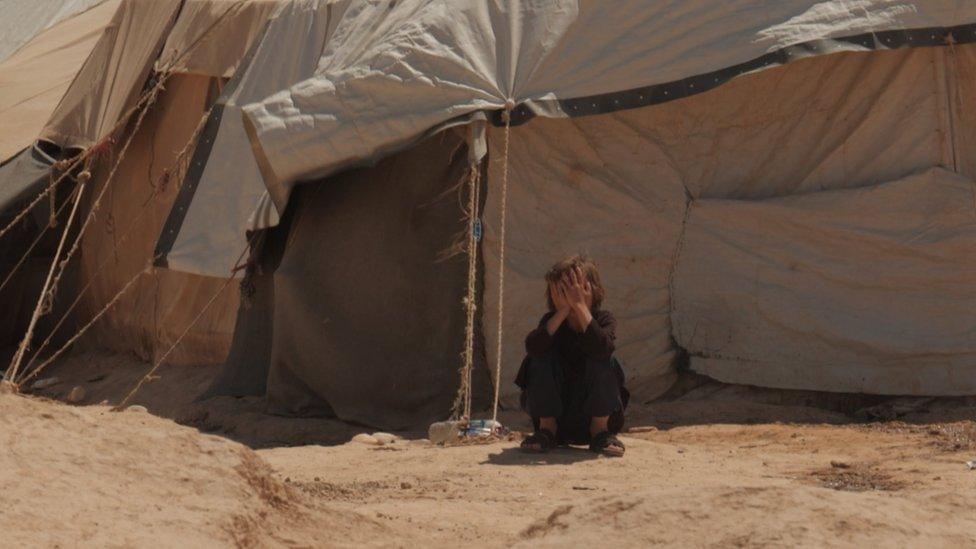 Child outside a tent