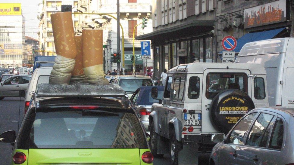 A car from an Italian association against cancer, with stubbed out cigarettes on its roof, is stopped in the traffic in Milan, 20 September 2007