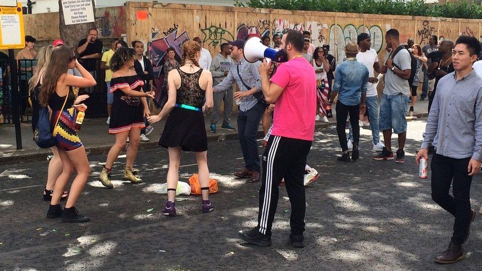 Man with megaphone and dancers