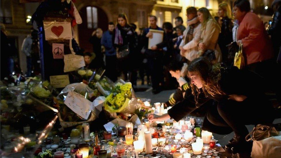 People light candles at a memorial in Paris