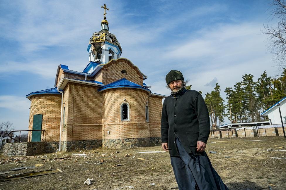 Roman, priest of Yasnohorodka, stands in front of his church