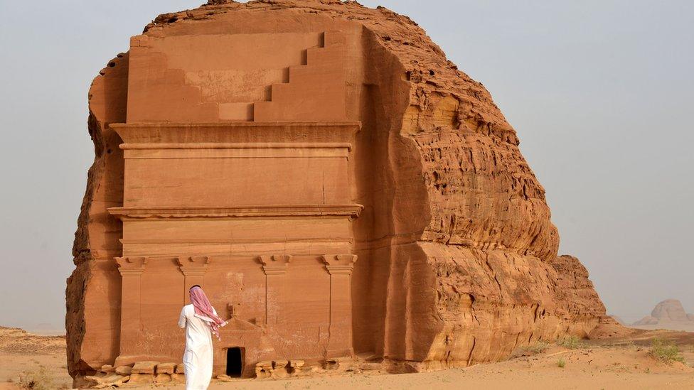 Man stands outside of the Qasr al-Farid tomb in Madain Saleh, a UNESCO World Heritage site, near the town of al-Ula in Saudi Arabia