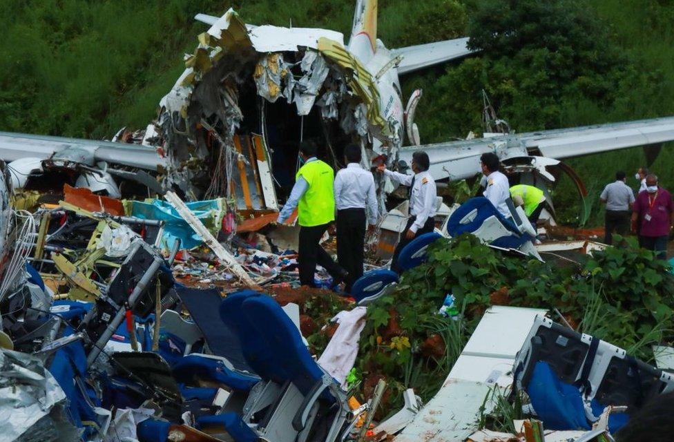 Officials inspect the wreckage of an Air India Express jet at Calicut International Airport in Karipur, Kerala, on August 8, 2020.