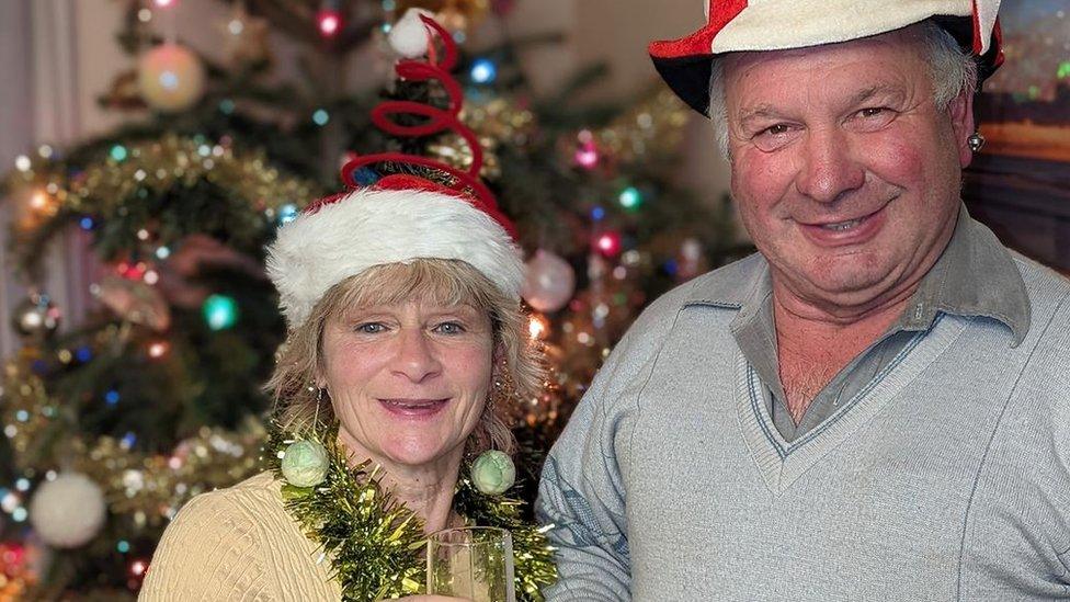 Christine and Didier in front of Christmas tree