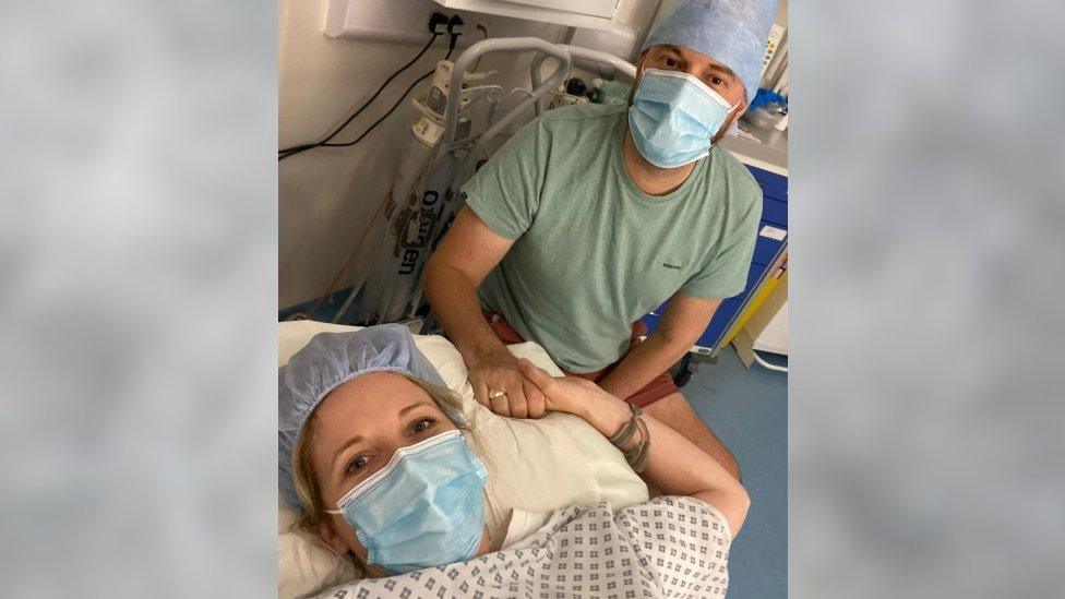 A woman and a man holding hands in a hospital bed