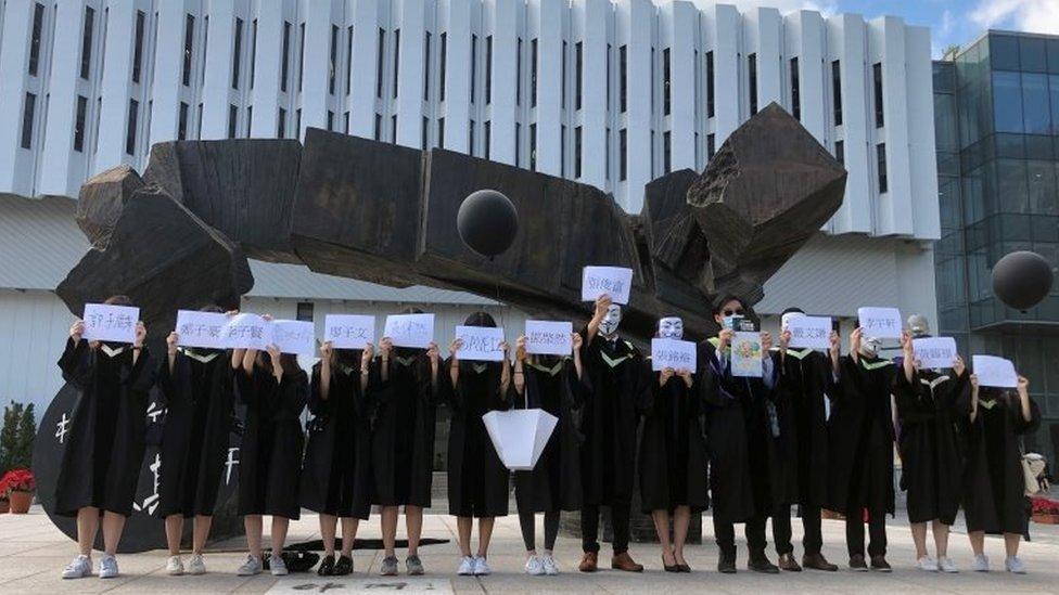 Chinese University students hold up the names of the 12 people held in mainland China