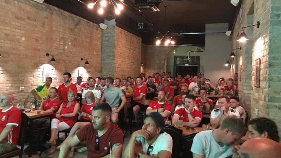 Cefnogwyr Cymru yn gwylio'r gêm mewn bar yn Budapest