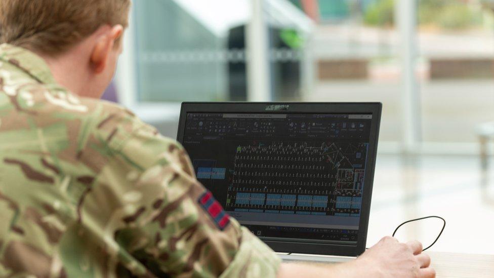 A member of the military on a laptop