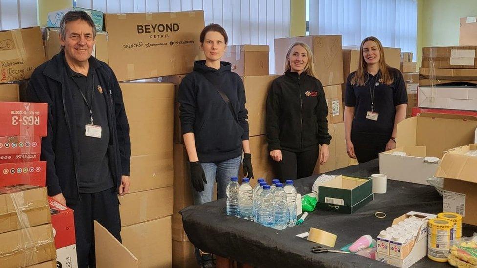 Essex Fire and Rescue team standing next to boxes filled with items to help refugees in Ukraine.