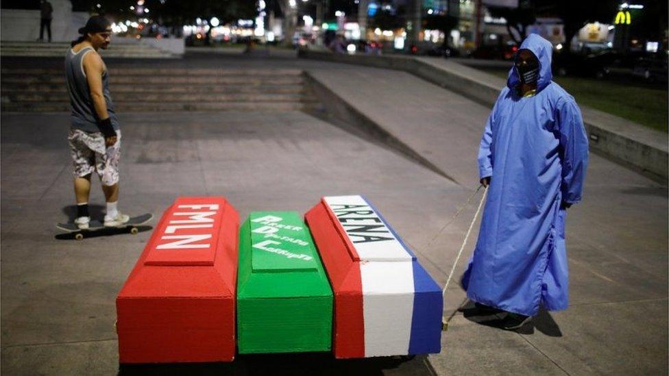 A supporter of the Nuevas Ideas political party drags fake coffins representing Salvadoran traditional political parties during a rally on the last day of election campaign in San Salvador, El Salvador, February 24, 2021.