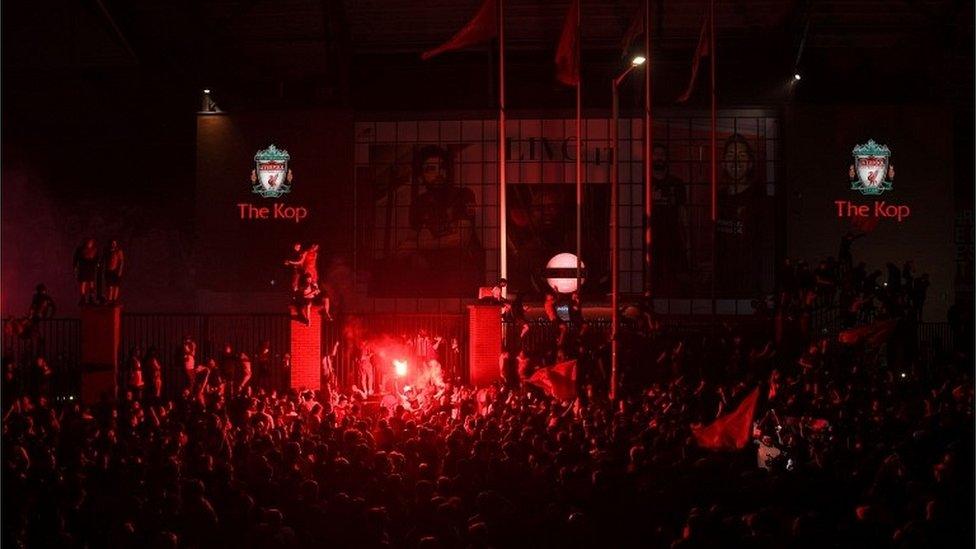 Fans celebrate Liverpool winning the Premier League title outside Anfield stadium