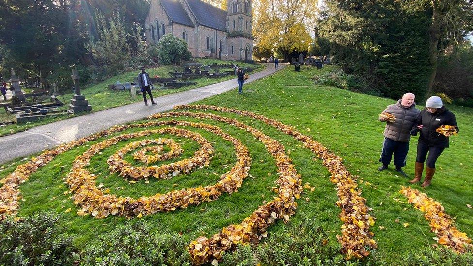 A land sculpture featuring autumn leaves spiralling out from a centre point