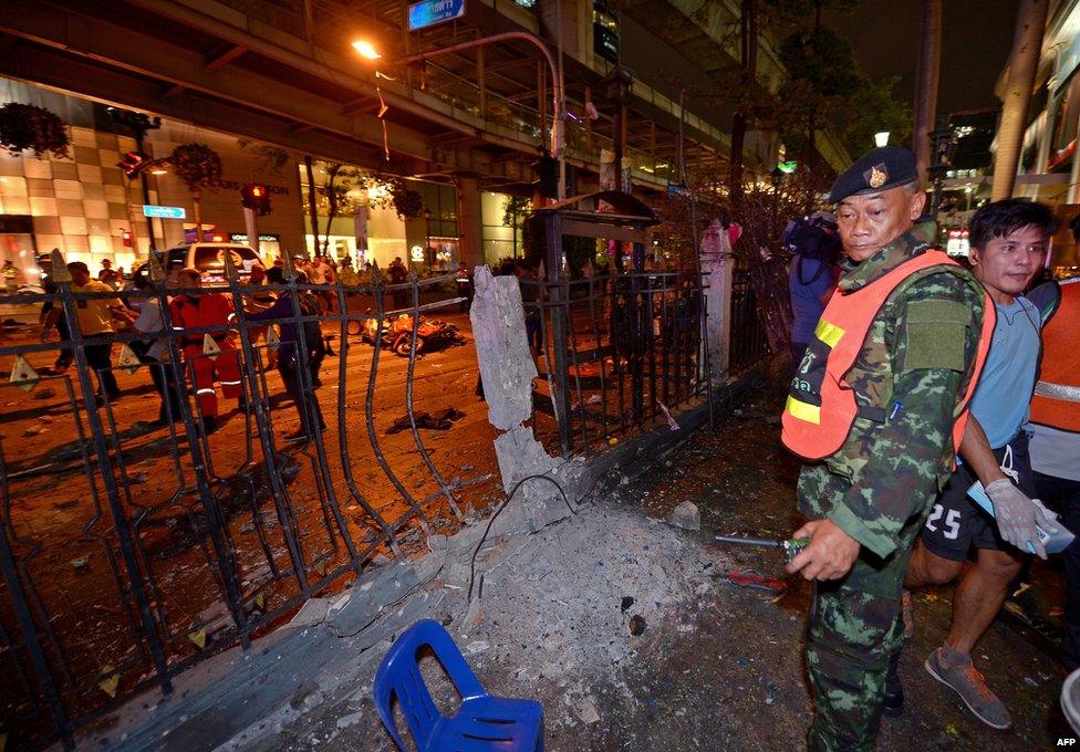 A Thai soldier (R) looks at the damage after a bomb exploded outside a religious shrine in central Bangkok late on 17 August 2015 killing at least 10 people and wounding scores more.