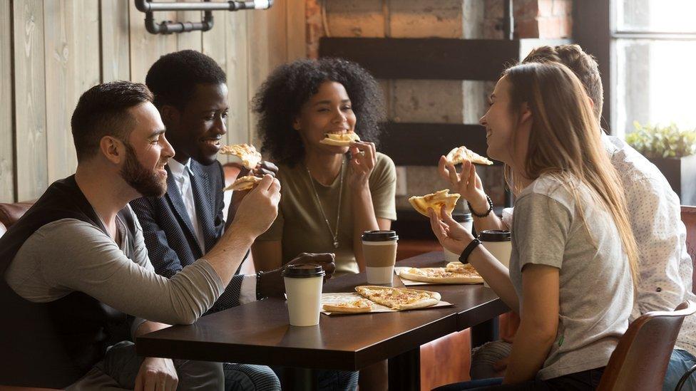 Group of people eating pizza