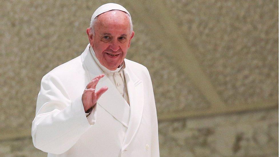 Pope Francis in white robes, waving