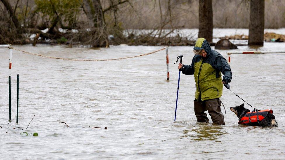 A woman walks through floods