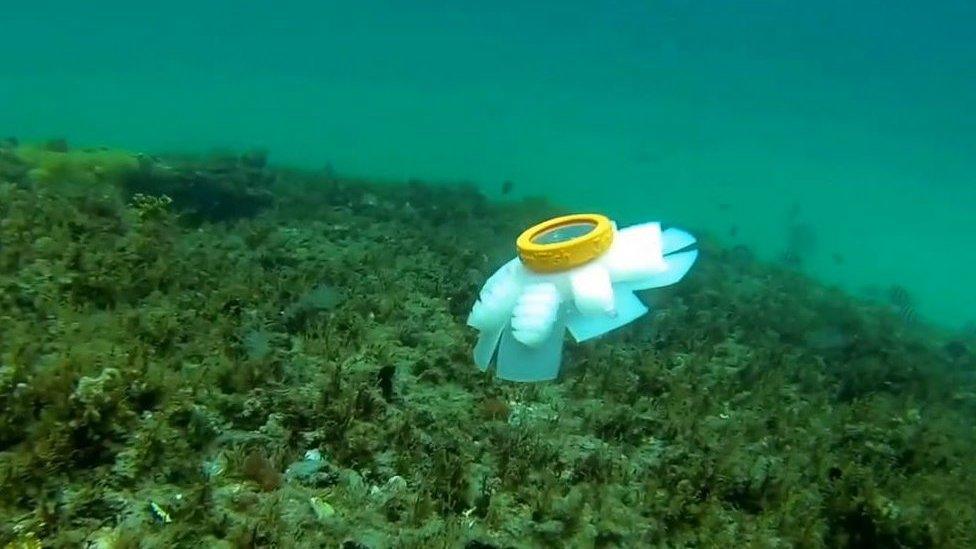 A jellyfish robot next to a coral reef