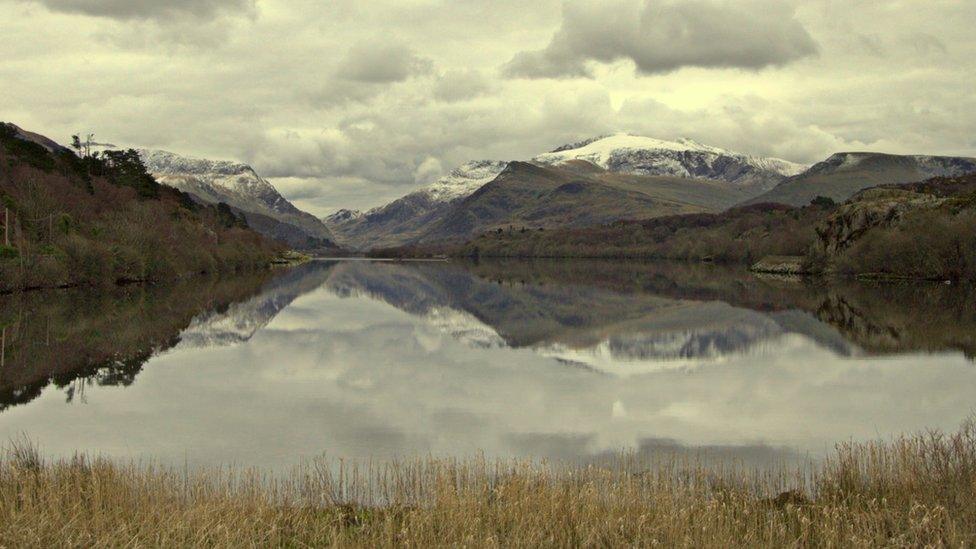 Snow-capped mountains behind Llyn Padarn in Snowdonia