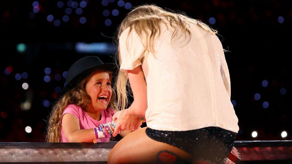 A young fan reacts after receiving a hat from Taylor Swift.