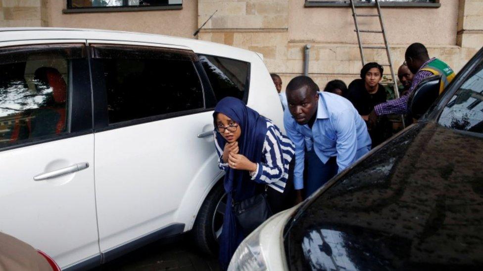 People are evacuated by a member of security forces at the scene where explosions and gunshots were heard at the Dusit hotel compound, in Nairobi, Kenya January 15, 2019.