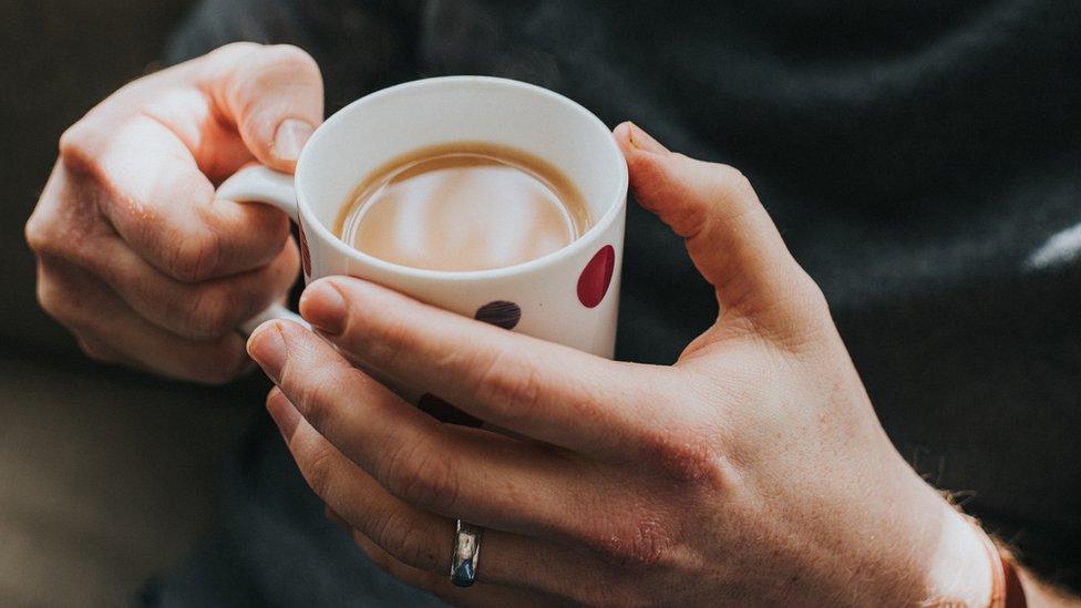 Hands holding mug