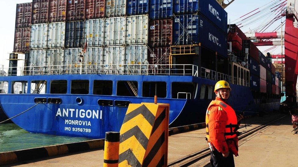 Man works beside a cargo ship in Qingdao port in eastern China.