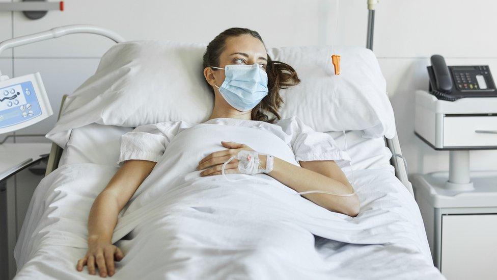 A stock image of a woman in a hospital bed