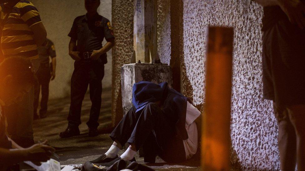 An alleged drug dealer is handcuffed after a drug buy bust operation conducted by policemen where they caught this 18 year old boy selling marijuana in Manila on May 12, 2018