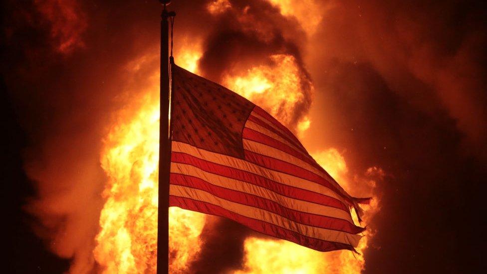 A flag outside a Department of Corrections building that burned in the protests