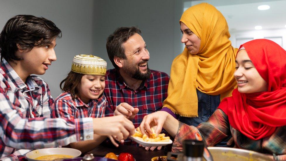 A Muslim family gathered around food during Ramadan