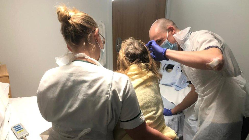 A physiotherapist helps a stroke sufferer to stand